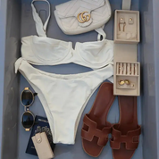 White bikini set with Gucci handbag, sunglasses, wallet, and sandals, travel jewellery box in a tray